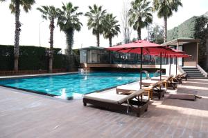 a swimming pool with chairs and an umbrella and a house at Boris Hotel Istanbul Beylikduzu in Beylikduzu