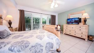 a bedroom with a bed and a television and a balcony at 609 Mariners Club in Key Largo +56 photos