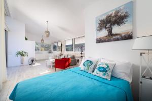 a bedroom with a blue bed and a living room at Dream View Loft in Lithakia