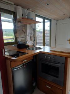 a kitchen with a sink and a stove at la cabane des remparts in Marsac-en-Livradois