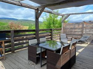 a patio with a table and chairs on a deck at la cabane des remparts in Marsac-en-Livradois