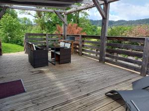 a wooden deck with a table and chairs on it at la cabane des remparts in Marsac-en-Livradois +12 photos