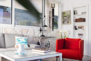 a living room with a couch and a red chair at Dream View Loft in Lithakia