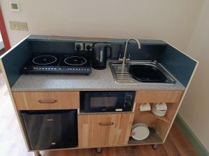 a small kitchen with a sink and a stove at Lodge Two The Old Gasworks in Milverton