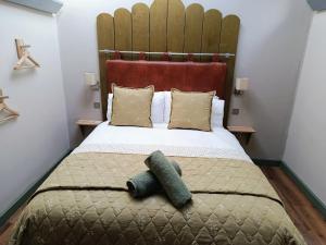 a bedroom with a bed with a headboard and pillows at Lodge Two The Old Gasworks in Milverton