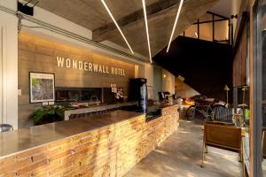 a bar in a restaurant with a sign on the wall at Wonderwall Hotel in Chiang Mai