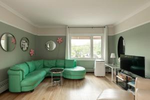 a living room with a green couch and a table at #Le80ies - Downtown Rooftop - Free shuttle to ski Mountain in Mont-Tremblant