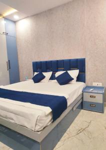 a bed with blue and white sheets and pillows at Hotel Kashi Bliss in Varanasi