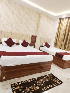 a bedroom with two beds and a rug at Hotel Kashi Bliss in Varanasi +12 photos
