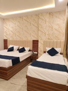 two beds in a hotel room with two at Hotel Kashi Bliss in Varanasi