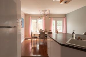 a kitchen with a table with chairs and a dining room at #Le80ies - Downtown Rooftop - Free shuttle to ski Mountain in Mont-Tremblant
