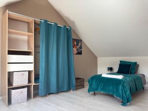 a bedroom with a bed and a blue curtain at Gîte du Palais 3 étoiles in Châteauneuf-sur-Cher