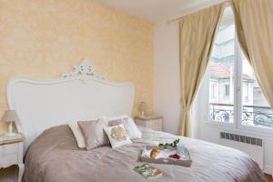 パリにあるApartment Ternesのベッドルーム(大きな白いベッド1台、窓付)