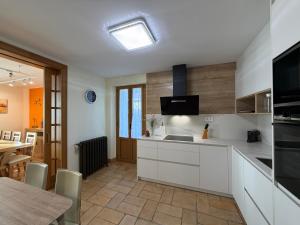 a kitchen with white cabinets and a table and a dining room at Cortea I y II in Añézcar +21 photos