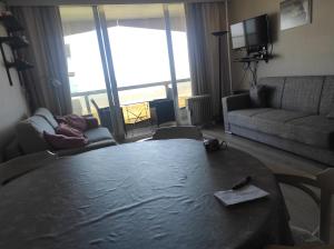 a living room with a table and a couch at Westdiep 602 zeezicht, verwarmd binnenzwembad in De Panne