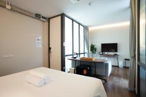 a bedroom with a bed and a desk and a television at Wonderwall Hotel in Chiang Mai +86 photos