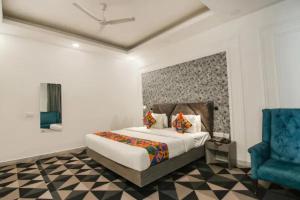 a bedroom with a bed and a blue chair at FabHotel Signature Luxe Inn - Chhattarpur in New Delhi +33 photos