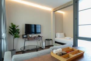 a living room with a couch and a tv at Wonderwall Hotel in Chiang Mai