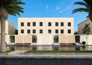 a white building with palm trees in front of it at Al-Jamwaut B in Medina