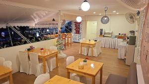 a restaurant with tables and chairs in a room at Sindy's Hostel in Pattaya
