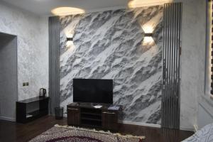 a living room with a tv and a marble wall at ADMIRAL in Termiz