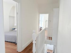 a white room with a bed and a stairway at The Cosy Nest Modern - 3BR House - Sleeps 7 - Near City Centre - STARLINK Wi-fi in Liverpool +16 photos