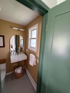 a bathroom with a sink and a toilet and a mirror at Gale River House - Boutique Hotel in Franconia +20 photos
