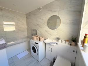 a bathroom with a washing machine and a sink at The Cosy Nest Modern - 3BR House - Sleeps 7 - Near City Centre - STARLINK Wi-fi in Liverpool