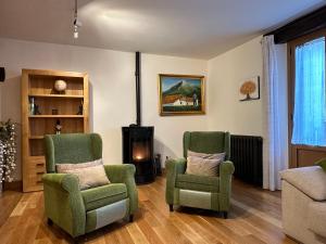 a living room with two chairs and a fireplace at Cortea I y II in Añézcar