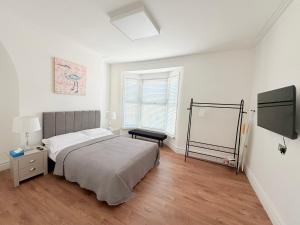 a bedroom with a bed and a flat screen tv at The Cosy Nest Modern - 3BR House - Sleeps 7 - Near City Centre - STARLINK Wi-fi in Liverpool