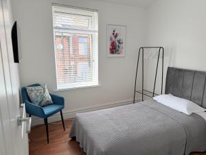 a bedroom with a bed and a chair and a window at The Cosy Nest Modern - 3BR House - Sleeps 7 - Near City Centre - STARLINK Wi-fi in Liverpool