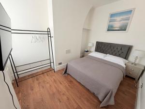 a bedroom with a bed and a dresser with a night stand at The Cosy Nest Modern - 3BR House - Sleeps 7 - Near City Centre - STARLINK Wi-fi in Liverpool
