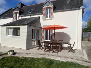 a patio with a table and an umbrella at Maison de pêcheurs in Trégunc