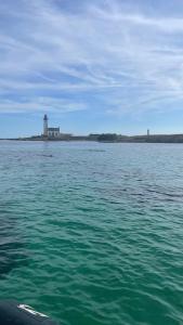 a large body of water with a lighthouse in the distance at Maison de pêcheurs in Trégunc +1 photo