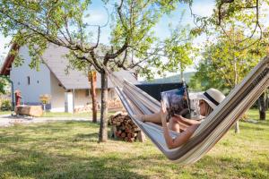 a woman laying in a hammock reading a book at a Ficak in Miskolc