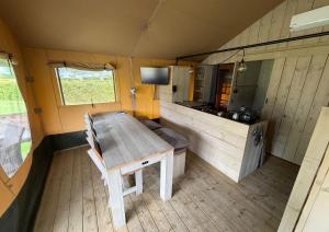a wooden table and chair in a tiny house at Safaritent Ranger Lodge in Kesteren