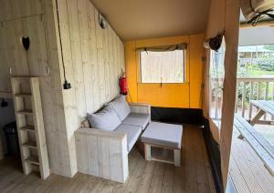 a small room with a couch and a window at Safaritent Ranger Lodge in Kesteren