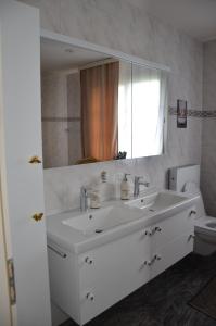 a bathroom with a sink and a mirror and a toilet at Auszeitloge in Nottwil +38 photos