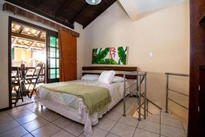 a bedroom with a bed and a table at Villa Garoupeta in Bombinhas