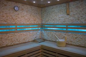 a sauna with wooden benches and a clock on the wall at Apartamenty Katowice by Lantier - Basen & Gabinet SPA in Bytom