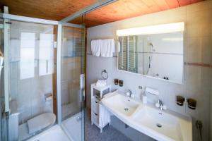 a bathroom with a sink and a shower and a toilet at Chalet Lena - Managed by Hotel Gstaaderhof in Gstaad