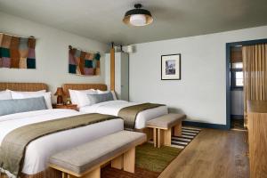 a hotel room with two beds and a window at Hotel Corduroy in Montauk