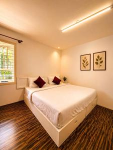 a bedroom with a large white bed with red pillows at Sunset Villa by Hyatt Stay in Avathi +47 photos