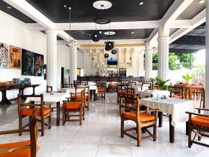 a restaurant with tables and chairs in a room at The Safiya Hotel Apartments in Ukunda