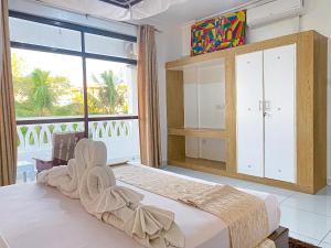 a bedroom with a large bed and a large window at The Safiya Hotel Apartments in Ukunda +74 photos