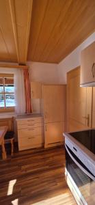 a kitchen with wooden cabinets and a table in a room at Gindlhütte in Tauplitzalm