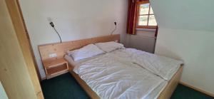 a small bedroom with a bed in a room at Gindlhütte in Tauplitzalm