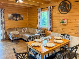 a dining room with a table and chairs and a couch at Willa Wilk in Międzybrodzie Bialskie
