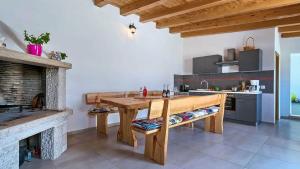 a kitchen with a wooden table and a fireplace at Sonnengarten floor 1 in Marčana