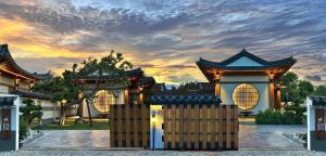 a house with a gate in front of a sunset at Krajokkaew Inyeon Khao Yai in Ban Khlong Yang